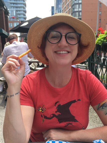 Headshot of Kira Braham holding a french fry.