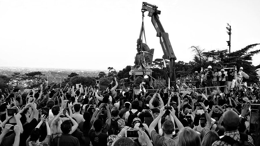 Black-and-white image of a large crowd watching and filming the crane removal of Cecil Rhodes' statue