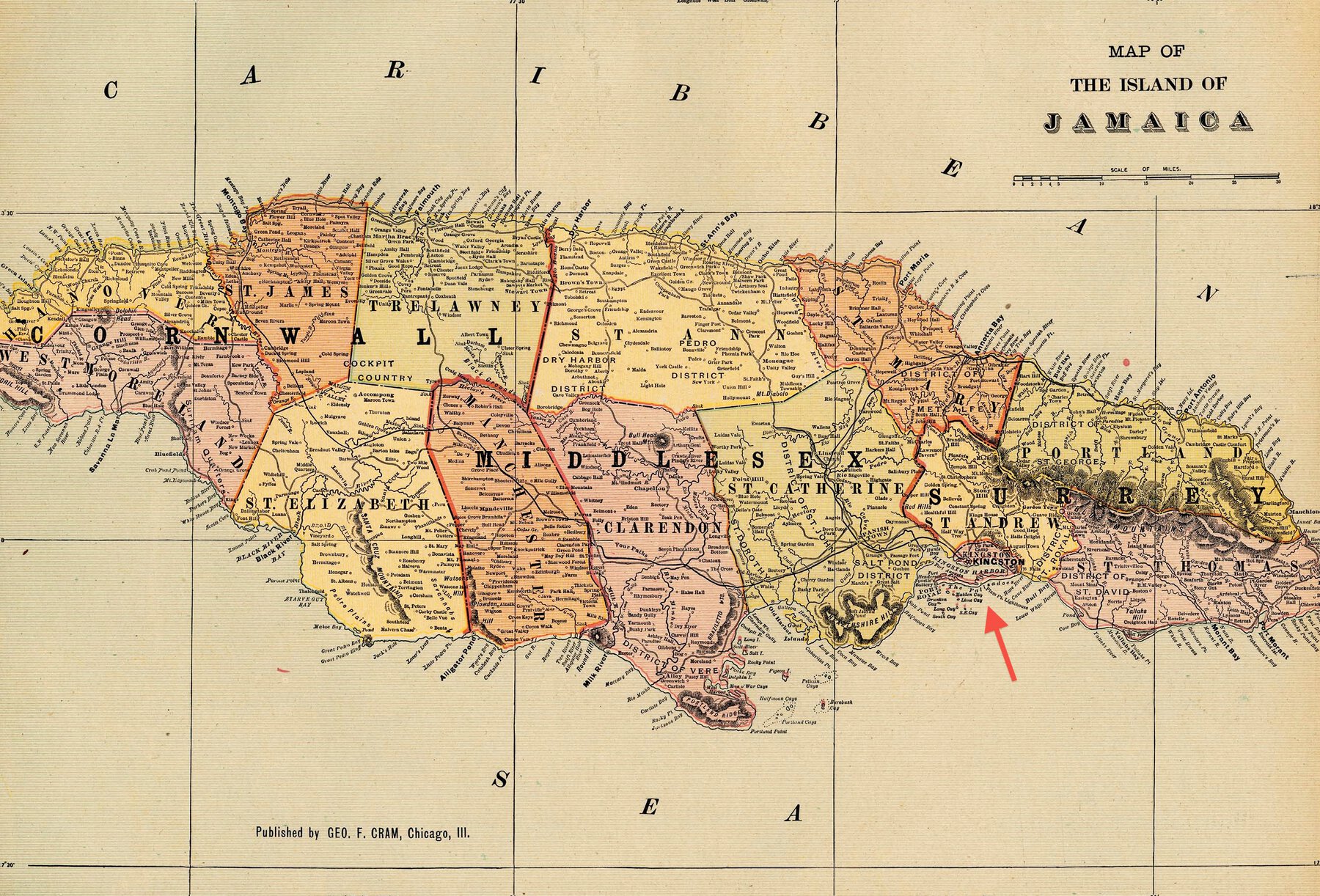 Printed color map of Jamaica with red arrow pointing to Kingston.