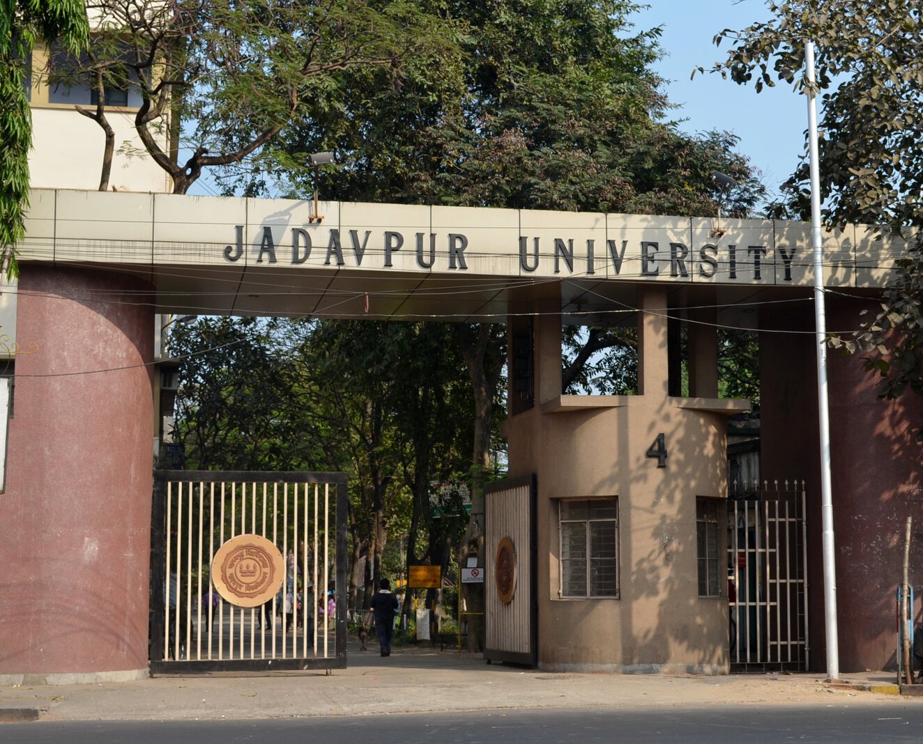 Gate of Jadavpur University with name written above and with one of two gate doors open.